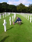 Frank Alfter placing srpig and poppy on 1Lt Gerald P. Davis' grave at Madingly.JPG